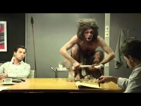 Escena de oficina con un cavernícola sobre la mesa